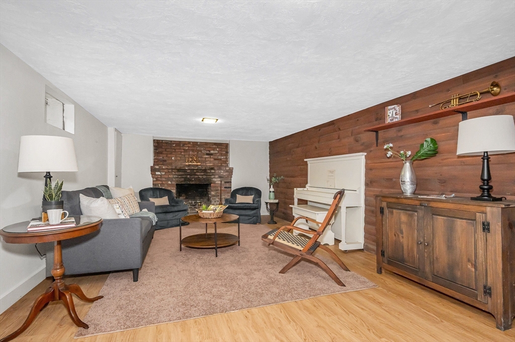 8 Greenwood Road Reading, MA 01867 - Photo 30 of 39 a living room with furniture a fireplace and a flat screen tv