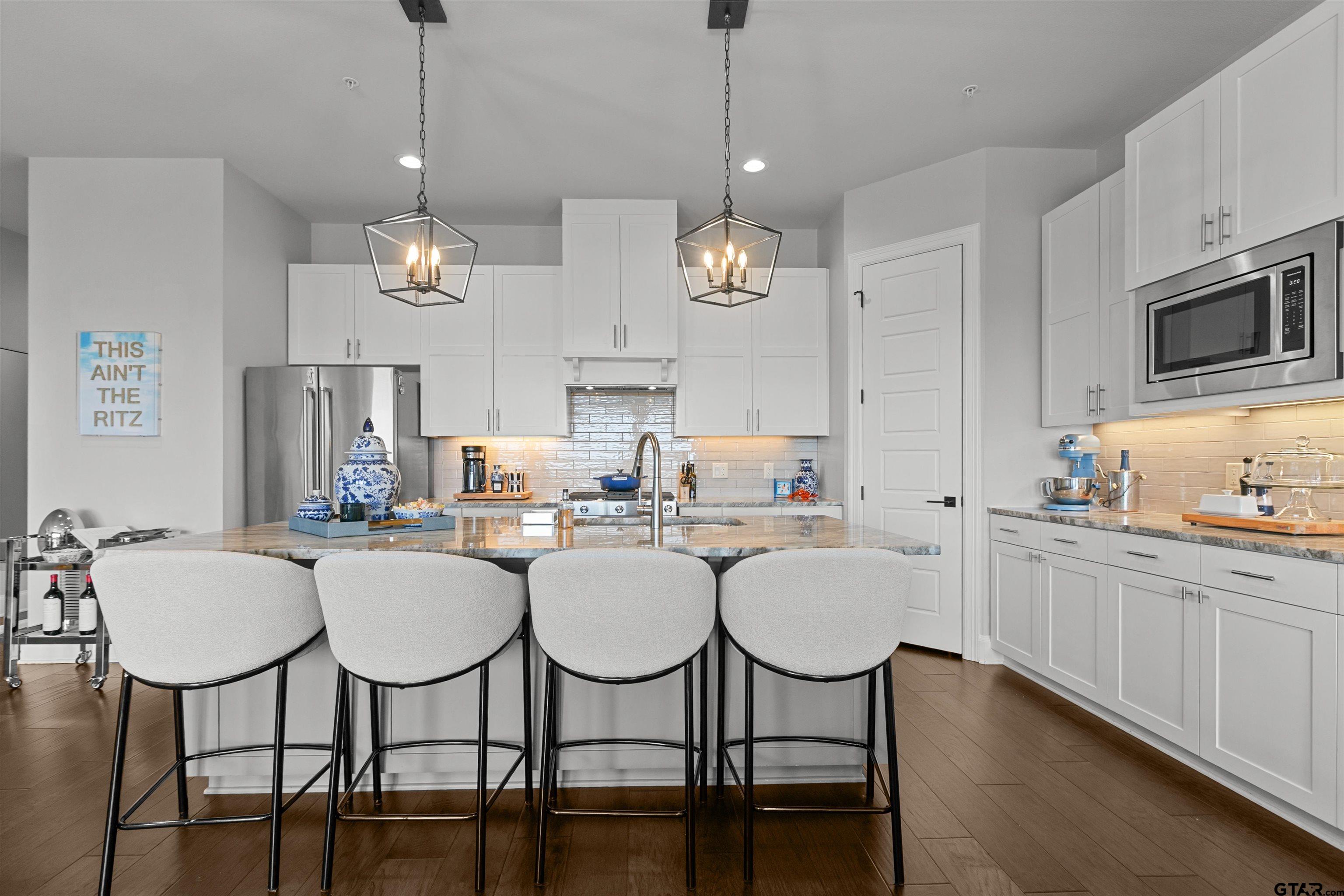 2981 Crest Ridge Drive, Unit 7 Tyler, TX 75703 - Photo 8 of 22 a kitchen with stainless steel appliances granite countertop a dining table chairs refrigerator and microwave