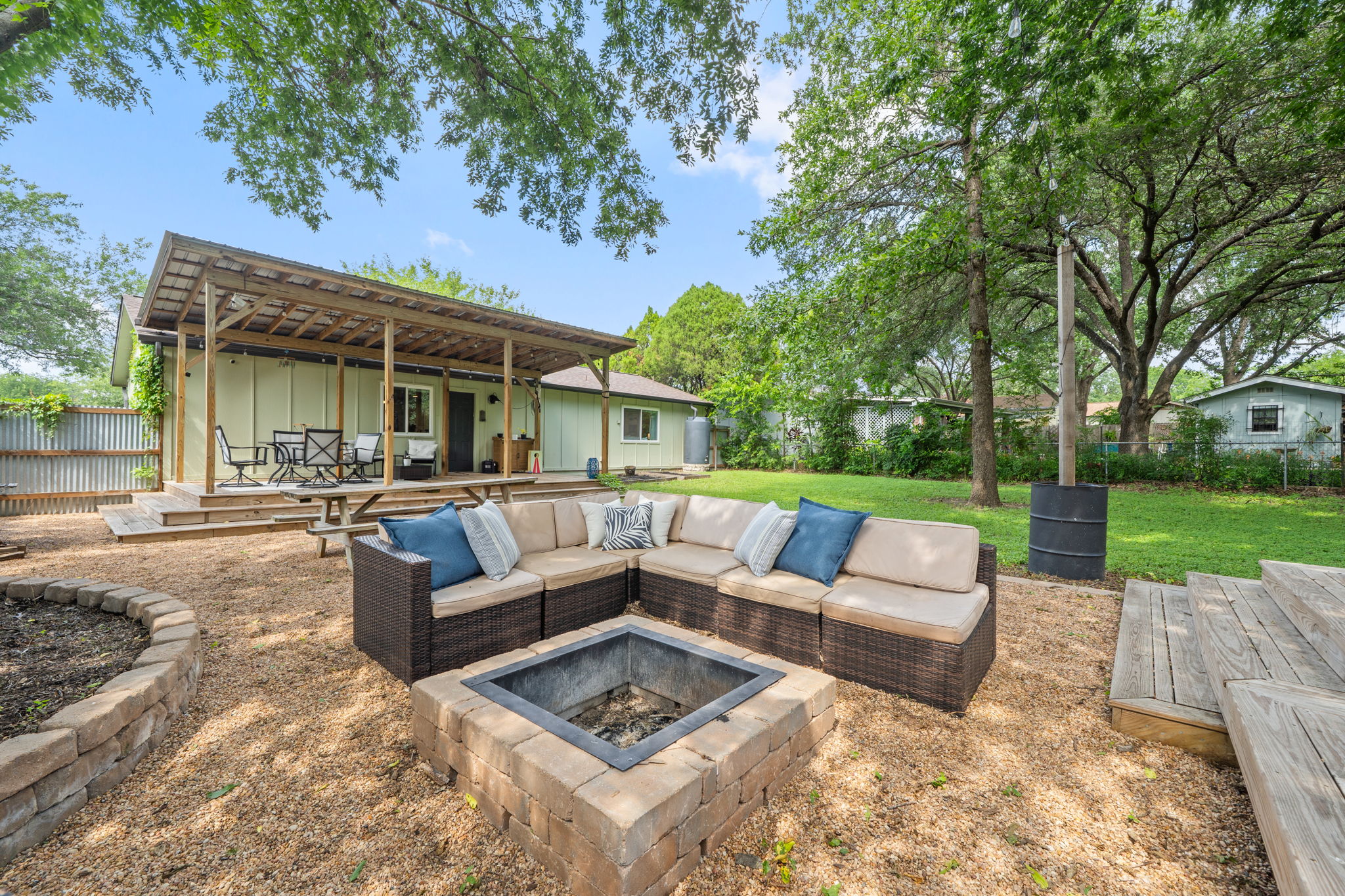 705 Dulwich Street Austin, TX 78748 - Photo 27 of 36 A spacious backyard retreat features a fire pit, comfortable outdoor seating, and a covered deck perfect for alfresco dining.