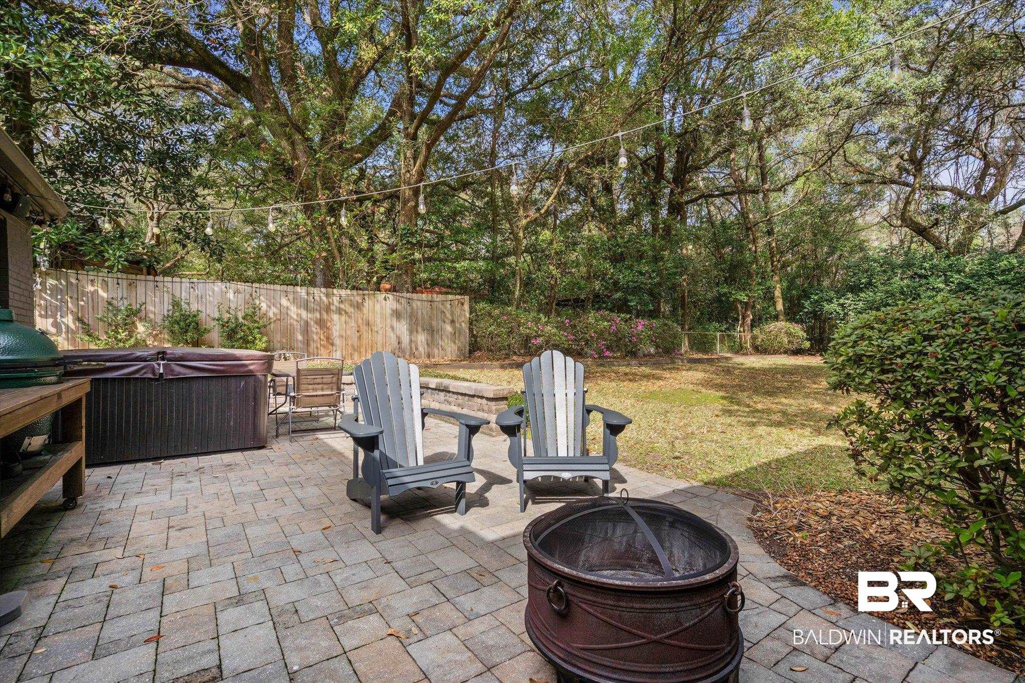 4590 Sunset Drive North Mobile, AL 36608 - Photo 27 of 35 Fenced backyard featuring an outdoor fire pit, a patio area, a hot tub, and a grill