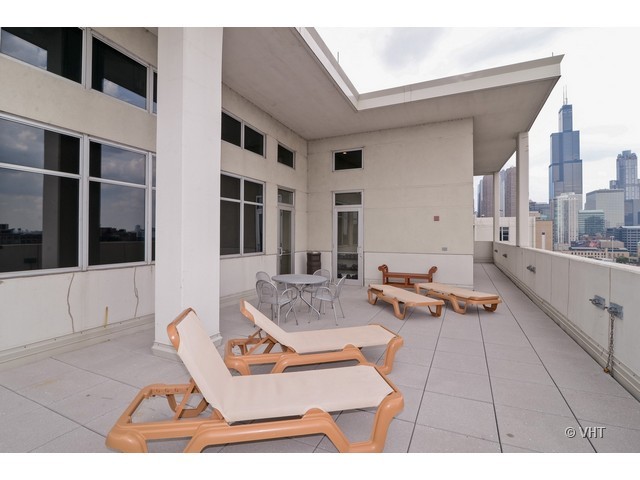 901 West Madison Street, Unit 809 Chicago, IL 60607 - Photo 12 of 12 a living room with patio furniture and a rug