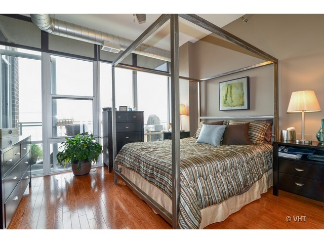 901 West Madison Street, Unit 809 Chicago, IL 60607 - Photo 6 of 12 a spacious bedroom with a bed and a large window