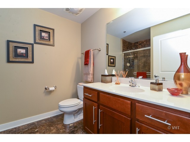 901 West Madison Street, Unit 809 Chicago, IL 60607 - Photo 9 of 12 a bathroom with a sink a toilet and a mirror