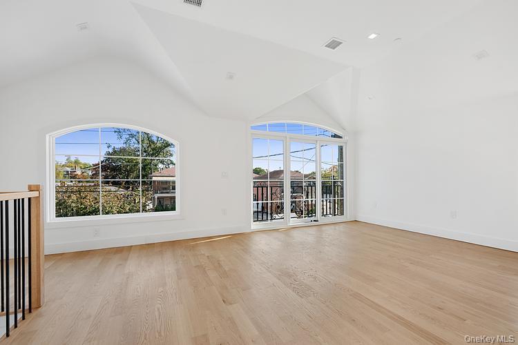 38-40 215th Street Queens, NY 11361 - Photo 19 of 35 Unfurnished living room featuring light wood-style floors and high vaulted ceiling