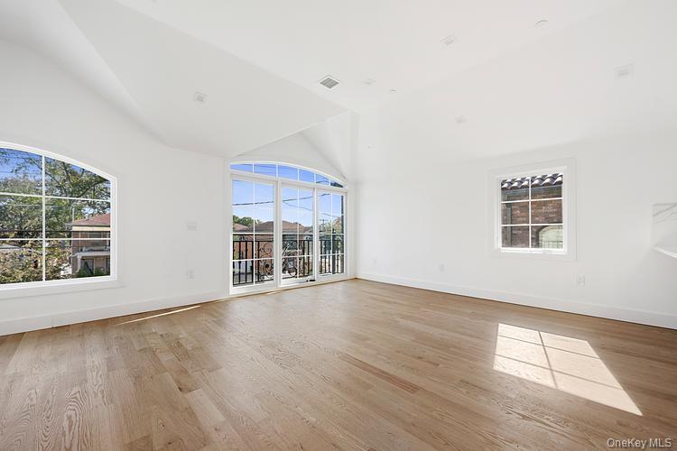 38-40 215th Street Queens, NY 11361 - Photo 21 of 35 Unfurnished room with high vaulted ceiling, plenty of natural light, and light wood-style flooring