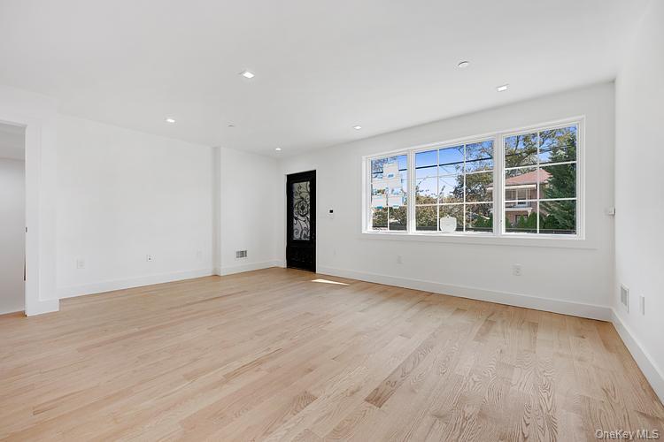 38-40 215th Street Queens, NY 11361 - Photo 28 of 35 Empty room with light wood finished floors and recessed lighting