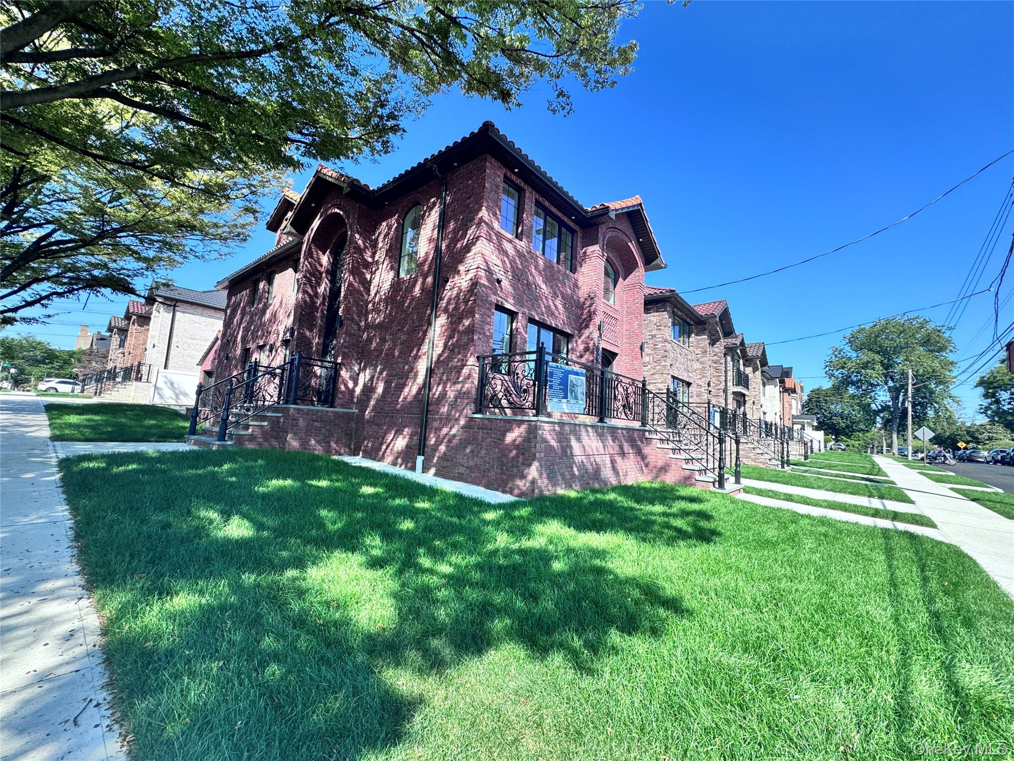38-40 215th Street Queens, NY 11361 - Photo 3 of 35 View of side of home with a yard, a tiled roof, and brick siding