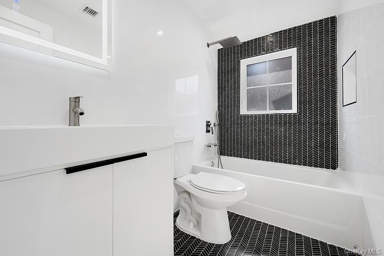 38-40 215th Street Queens, NY 11361 - Photo 8 of 35 Full bath with vanity, bathtub / shower combination, and tile patterned floors