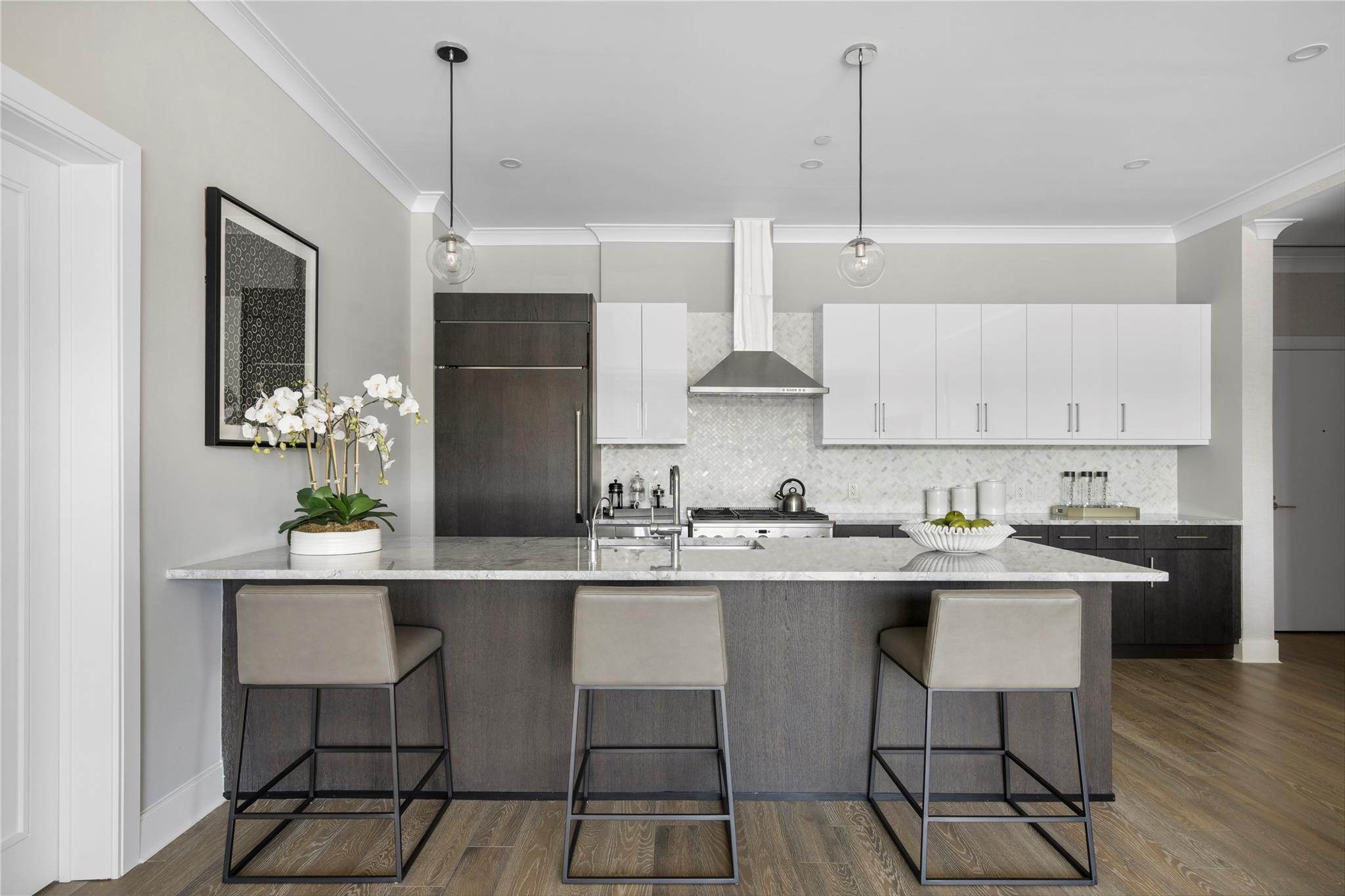 100 Garvies Point Road, Unit 1211 Glen Cove, NY 11542 - Photo 6 of 24 Kitchen with a breakfast bar area, white cabinetry, dark hardwood / wood-style floors, paneled built in fridge, and wall chimney exhaust hood