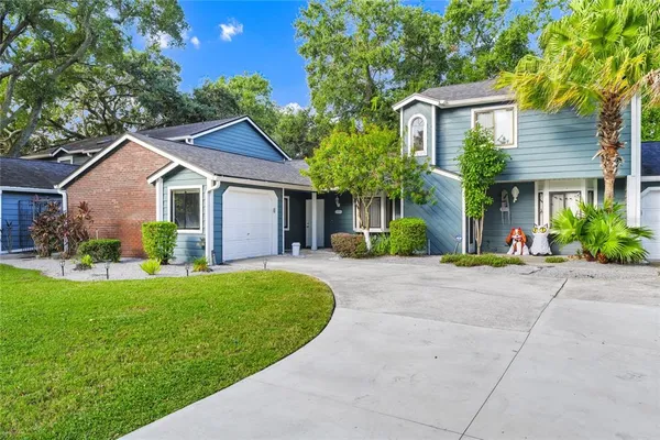 a view of a house with a yard and potted plants