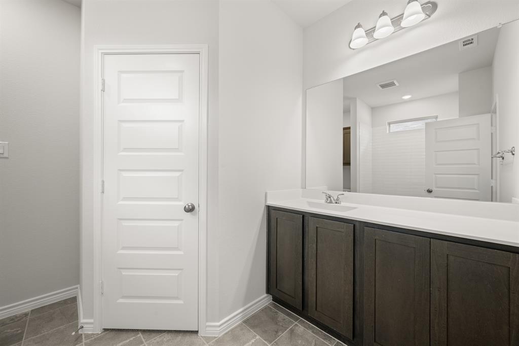 409-411 Saddle Drive Denton, TX 76209 - Photo 17 of 29 a bathroom with a double vanity sink and a mirror