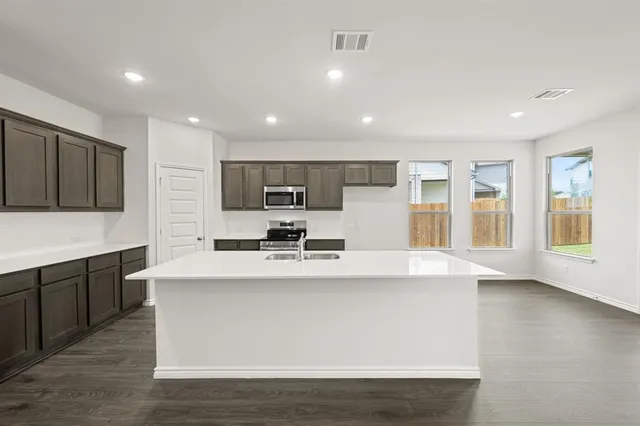 a kitchen with a sink stainless steel appliances and cabinets