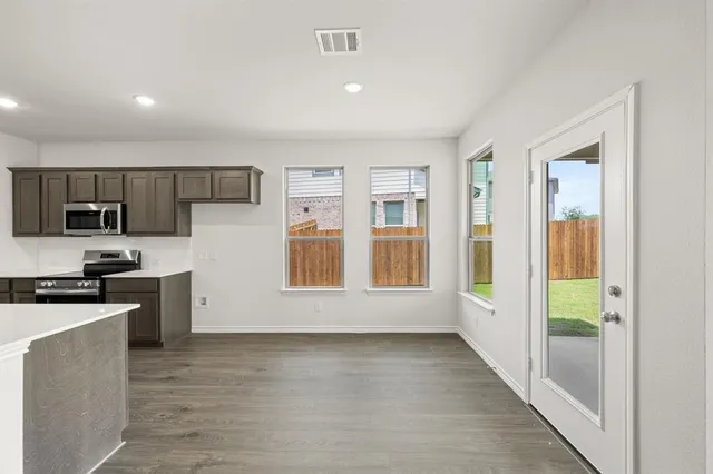 a view of empty room with wooden floor and window
