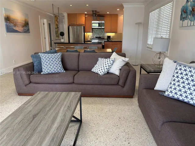 a kitchen with stainless steel appliances granite countertop a refrigerator a stove and a sink with wooden floor