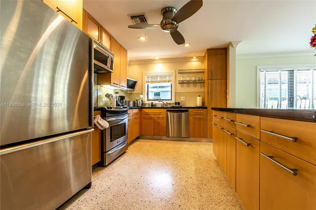 a kitchen with a dining table chairs and refrigerator