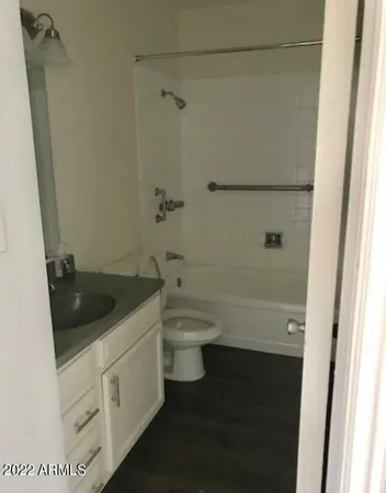a bathroom with a granite countertop toilet a sink and a bathtub