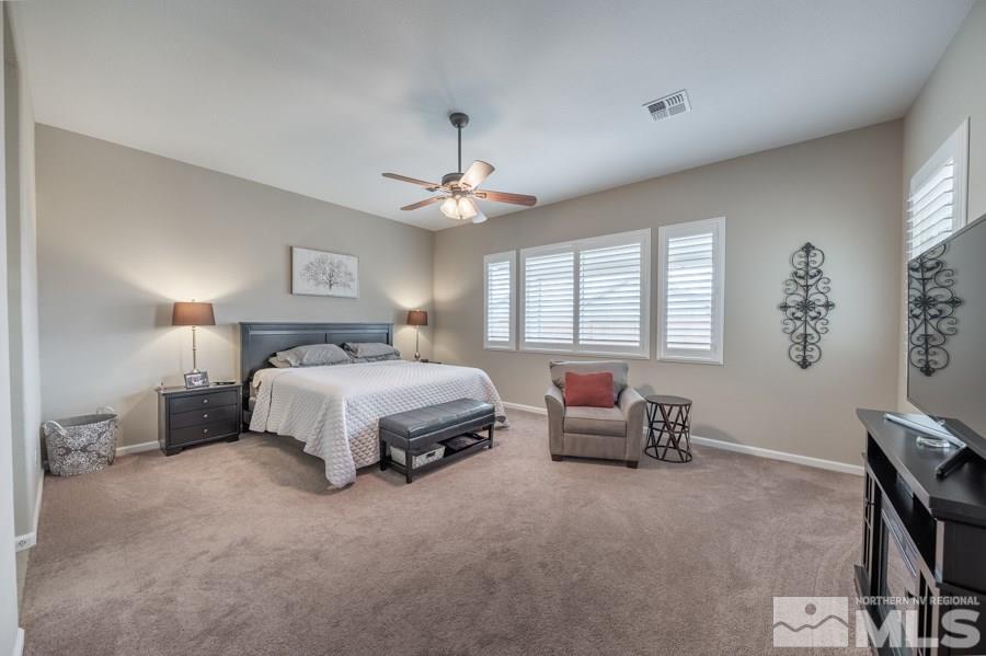 2285 Trakehner Lane, Unit NV Reno, NV 89521 - Photo 12 of 23 a spacious bedroom with a bed and a chandelier