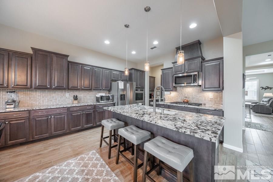 2285 Trakehner Lane, Unit NV Reno, NV 89521 - Photo 7 of 23 a kitchen with stainless steel appliances granite countertop a sink and a refrigerator