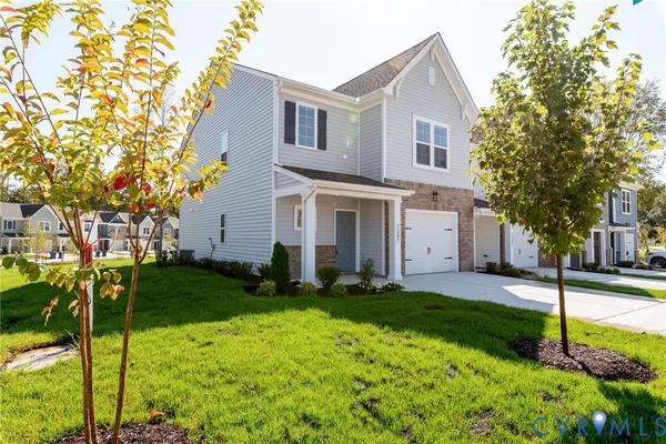 a front view of a house with a yard and trees