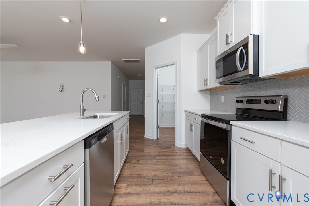 11301 Benton Pointe Way Chester, VA 23831 - Photo 12 of 29 a kitchen with stainless steel appliances granite countertop a sink a stove top oven and refrigerator