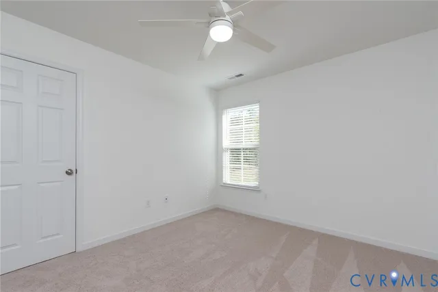 a view of an empty room with a window and closet area