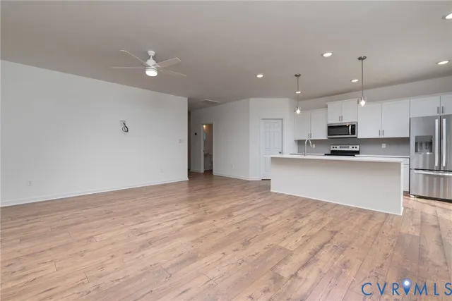 a view of kitchen with kitchen island microwave and cabinets