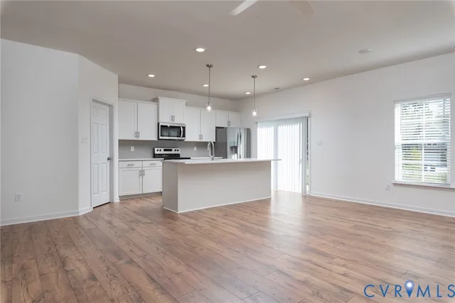 a view of kitchen with granite countertop stainless steel appliances refrigerator sink and cabinets