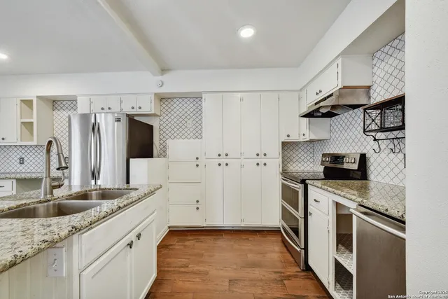 a kitchen with stainless steel appliances granite countertop a sink stove and refrigerator