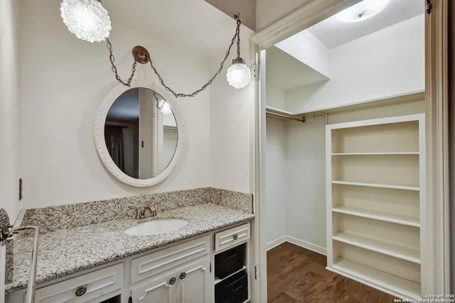 a bathroom with a granite countertop sink and a mirror