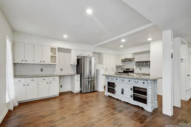 a kitchen with stainless steel appliances a stove top oven a refrigerator a sink and a oven