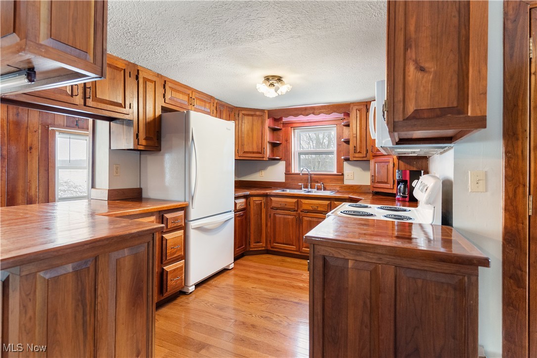 5070 Russell Road Andover, OH 44003 - Photo 17 of 25 Kitchen with sink, white refrigerator, butcher block countertops, stove, and light wood-type flooring