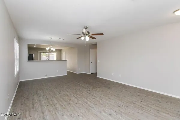 a view of a big room with windows and chandelier fan