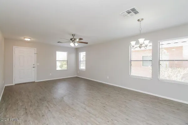 a kitchen with stainless steel appliances granite countertop a refrigerator a sink a stove top oven a refrigerator and white cabinets with wooden floor