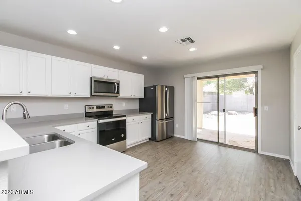 a kitchen with white cabinets and stainless steel appliances