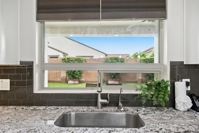 a kitchen with granite countertop white cabinets and stainless steel appliances