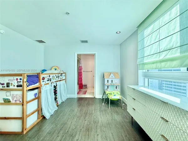 a view of a room with baby crib and furniture