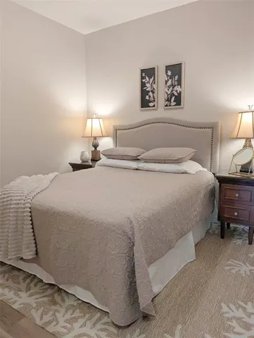 a bedroom with a bed and a lamp on table