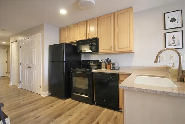 a kitchen with a refrigerator sink and cabinets