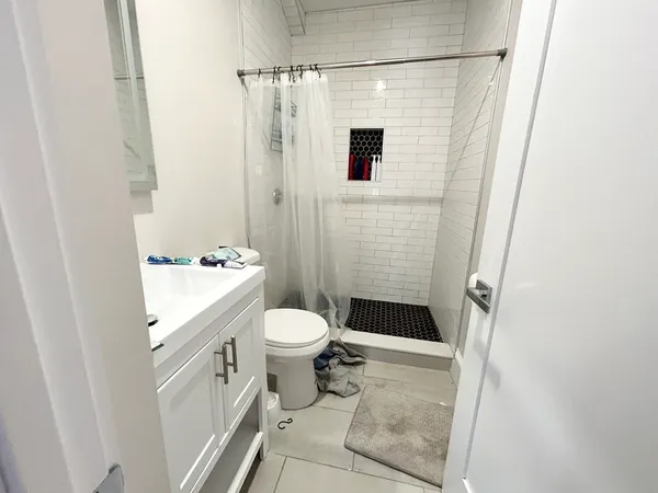 a bathroom with a granite countertop sink toilet and shower
