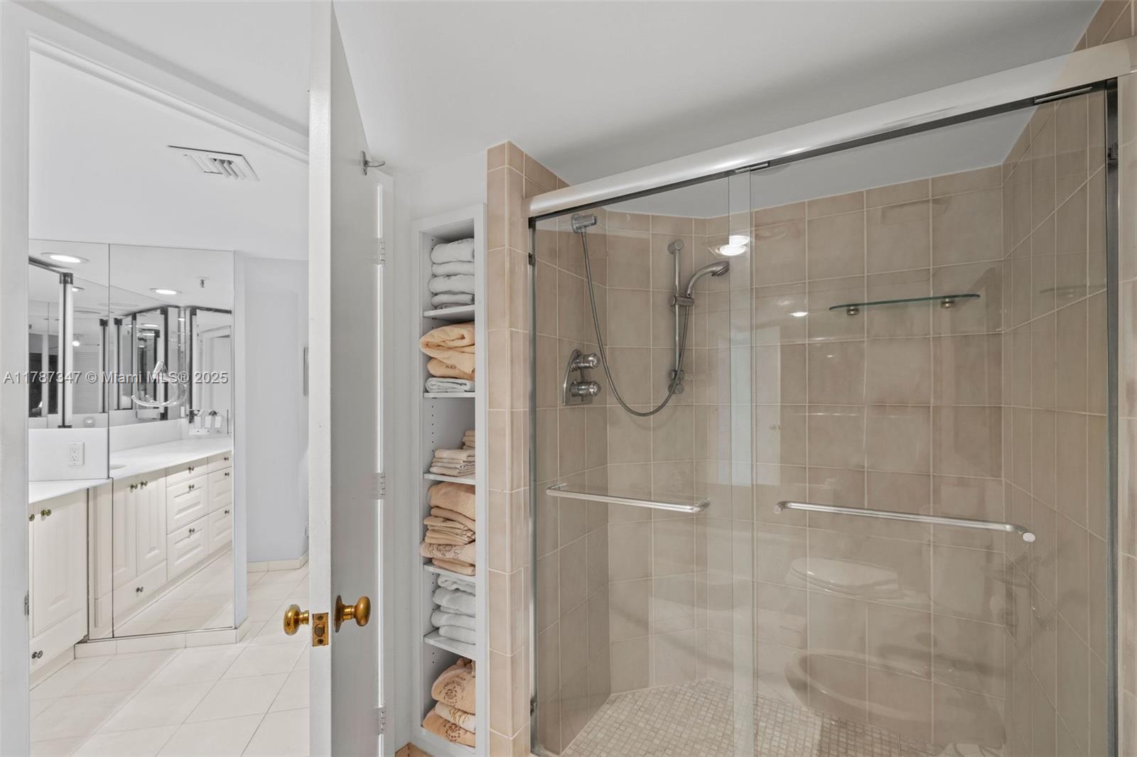 520 Brickell Key Drive, Unit A201 Miami, FL 33131 - Photo 24 of 52 a bathroom with a glass shower door and a mirror