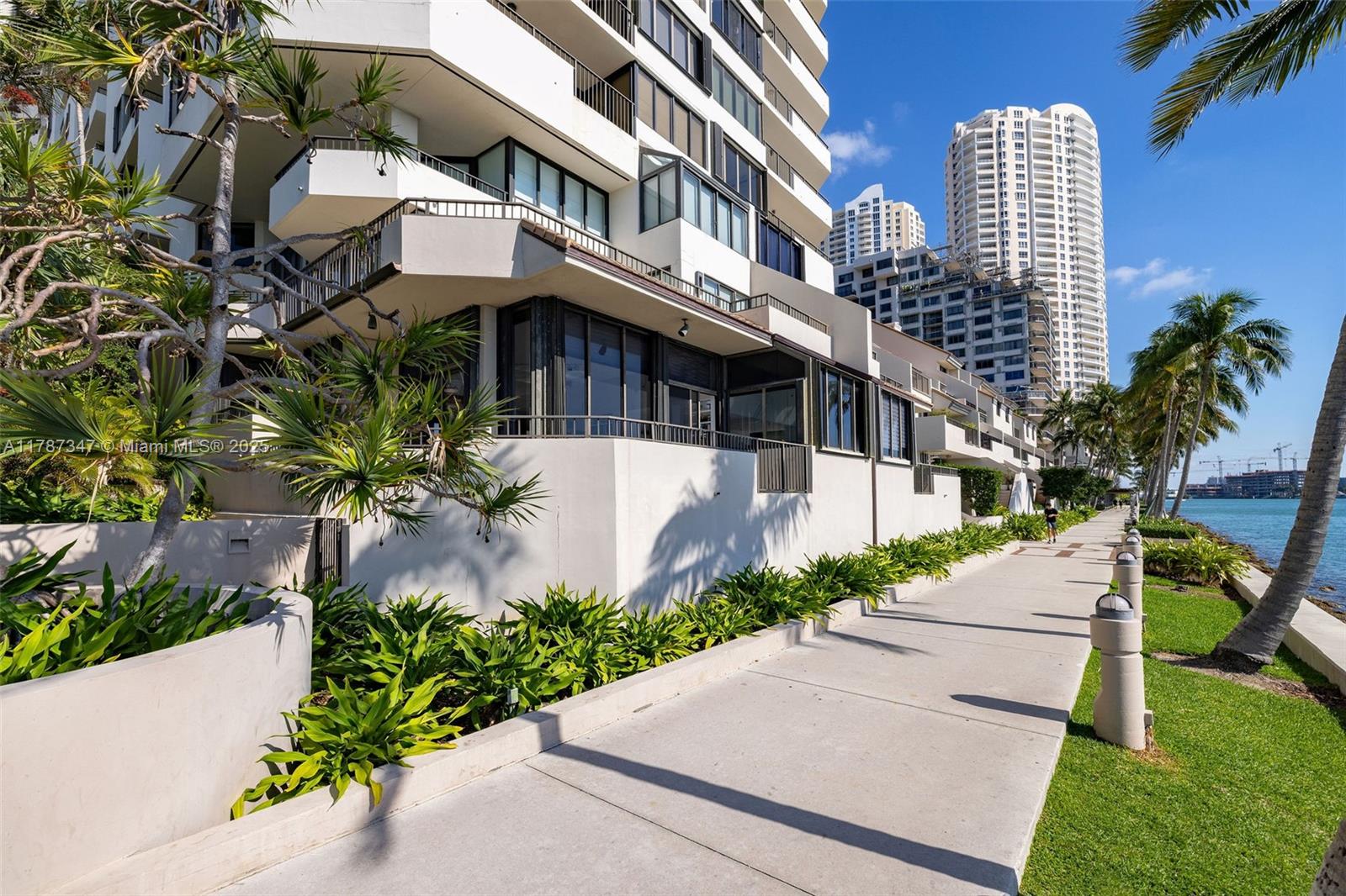 520 Brickell Key Drive, Unit A201 Miami, FL 33131 - Photo 42 of 52 a front view of a multi story residential apartment building with yard and bench