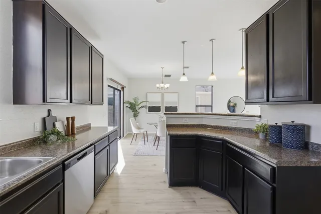 a kitchen with stainless steel appliances granite countertop a sink a stove and a wooden cabinets