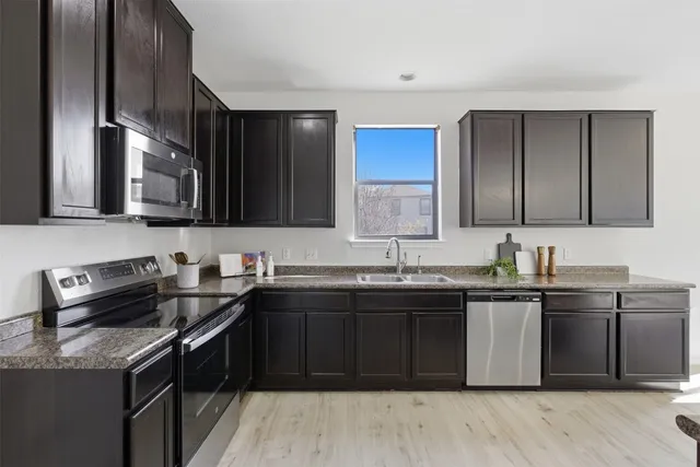 a kitchen with stainless steel appliances granite countertop a sink stove and cabinets