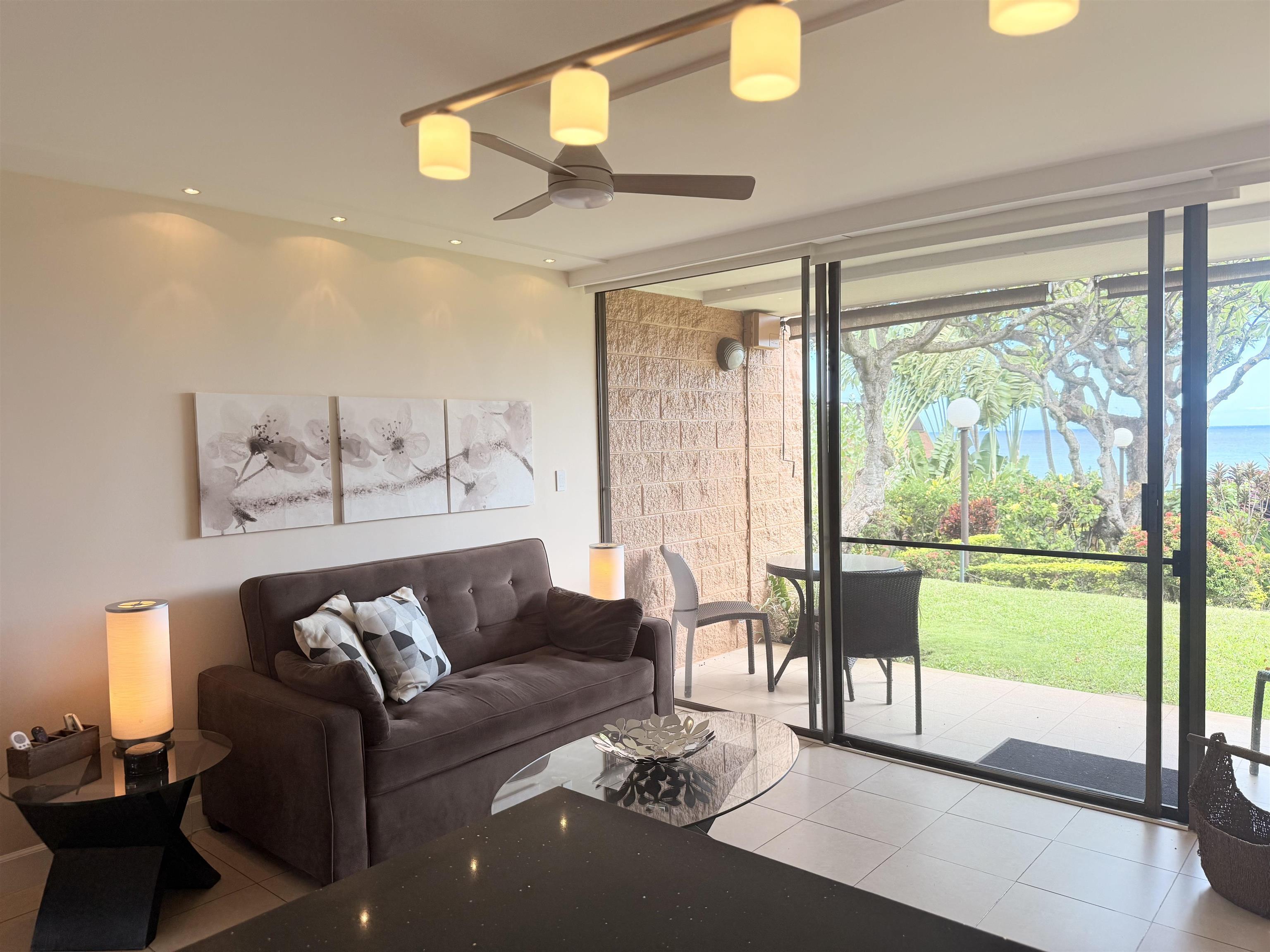 3959 Lower Honoapiilani Road, Unit 503 Lahaina, HI 96761 - Photo 5 of 47 a living room with furniture and a floor to ceiling window