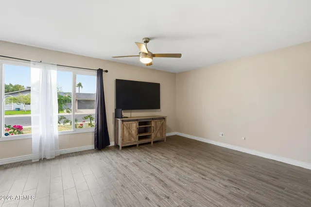 an empty room with windows flat screen tv and windows