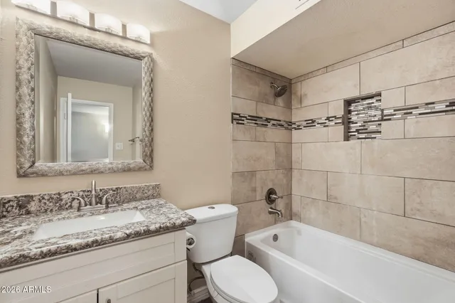 a bathroom with a granite countertop sink toilet and shower
