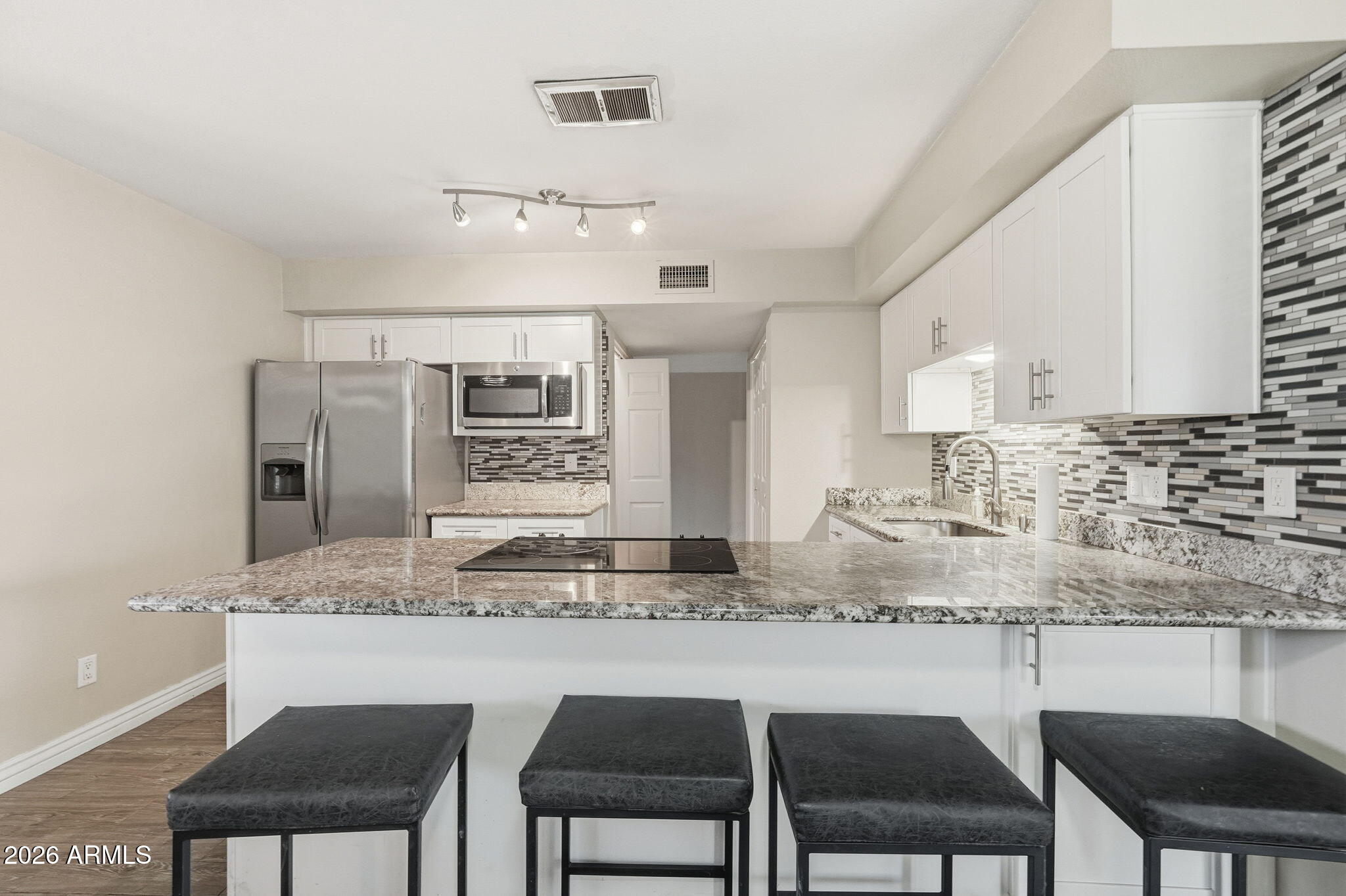 4526 South Terrace Road Tempe, AZ 85282 - Photo 9 of 30 a kitchen with granite countertop white cabinets and chairs