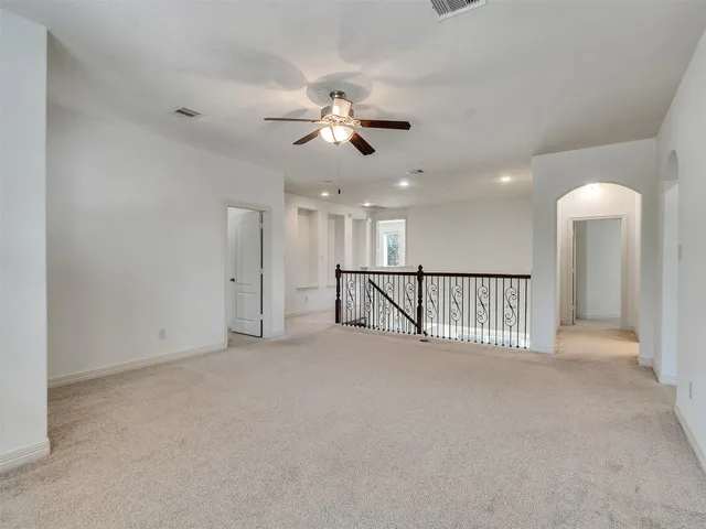 a view of a hallway with a ceiling fan