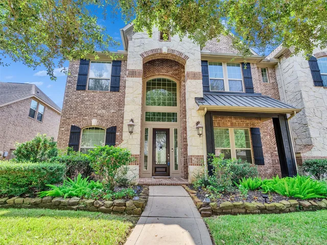 front view of a brick house with a yard