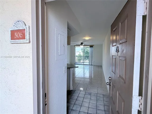 a view of a hallway with wooden floor and a bathroom